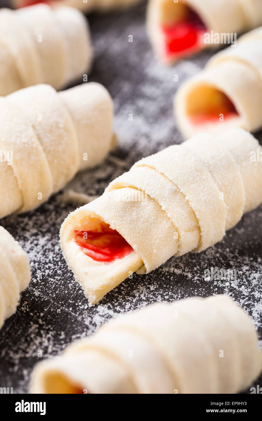Hacer croissants caseros rellenos con frambuesas dulces Foto de stock
