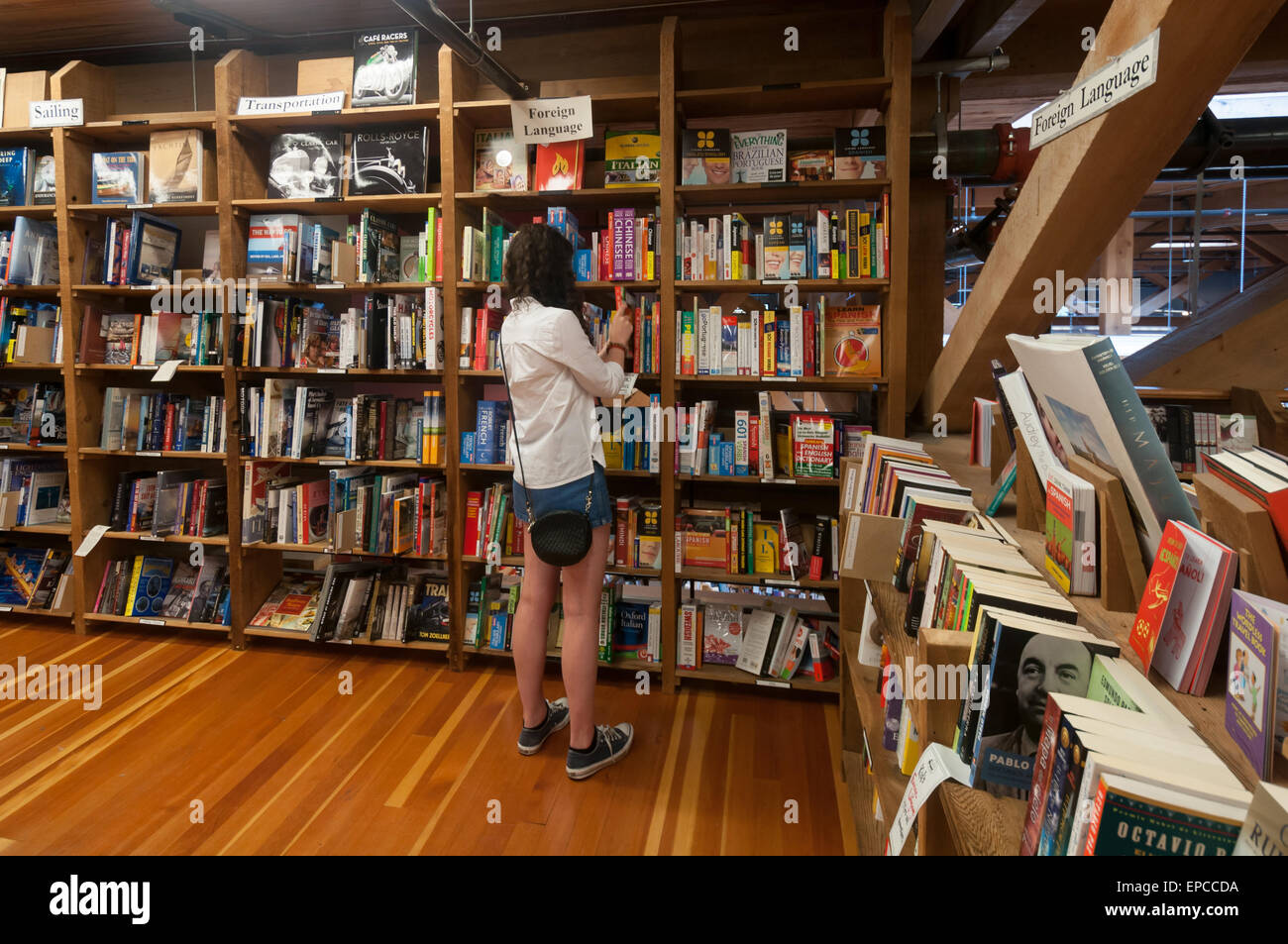 Chica mostrando la sección de lenguas extranjeras de la Bahía Elliot Book Company en Capitol Hill, en Seattle, Washington, EE.UU. Foto de stock