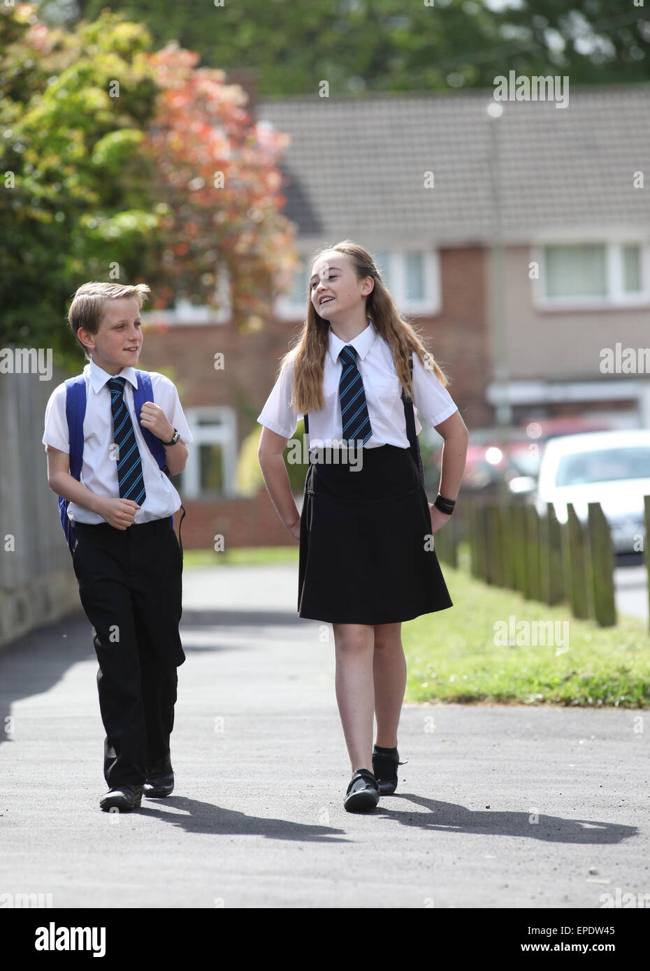Los escolares en uniforme ir caminando a la escuela UK Foto de stock