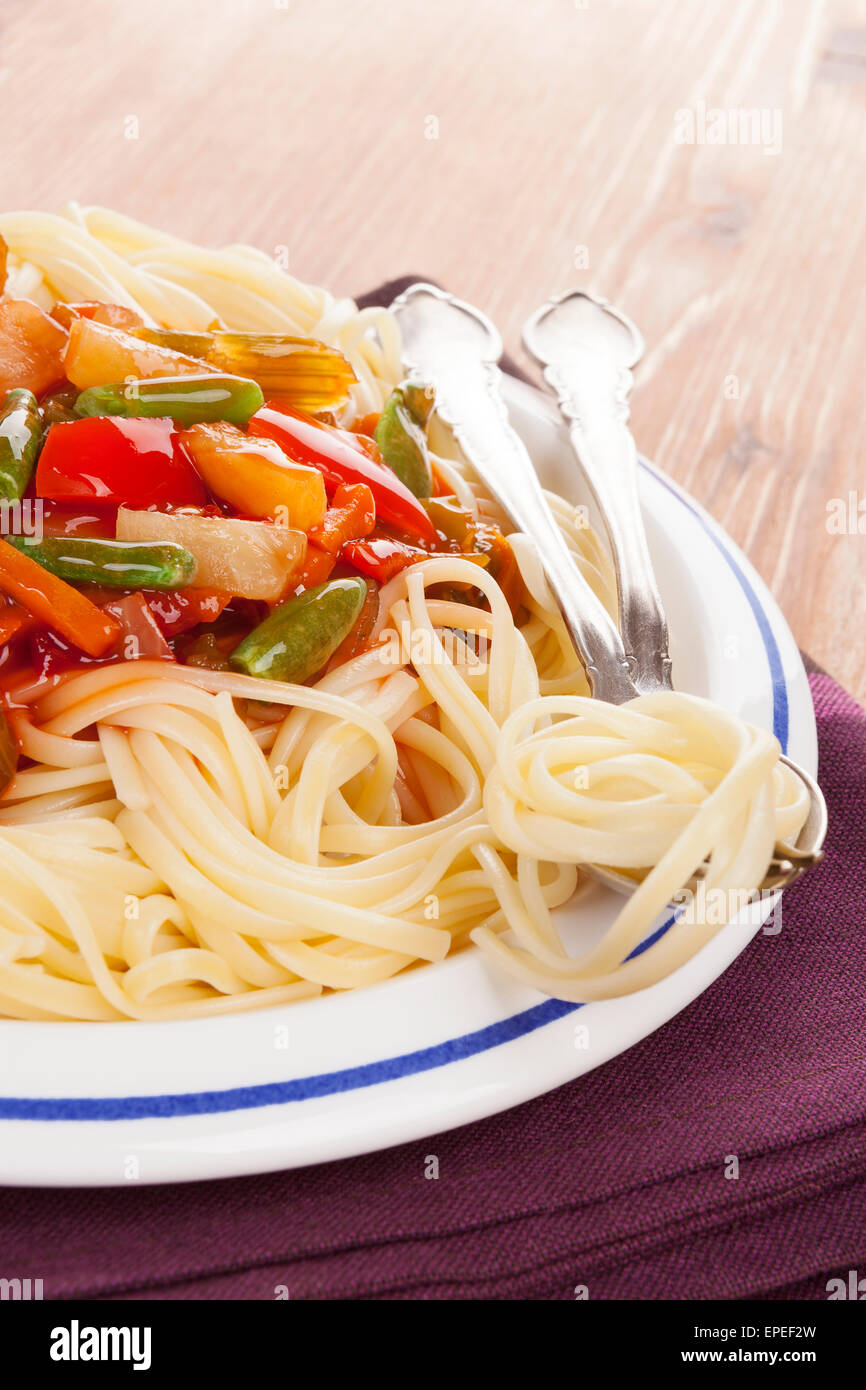 Unión culinaria de comer. Pasta espagueti con salsa de vegetales de tomate rojo en la placa en el fondo de madera. Foto de stock