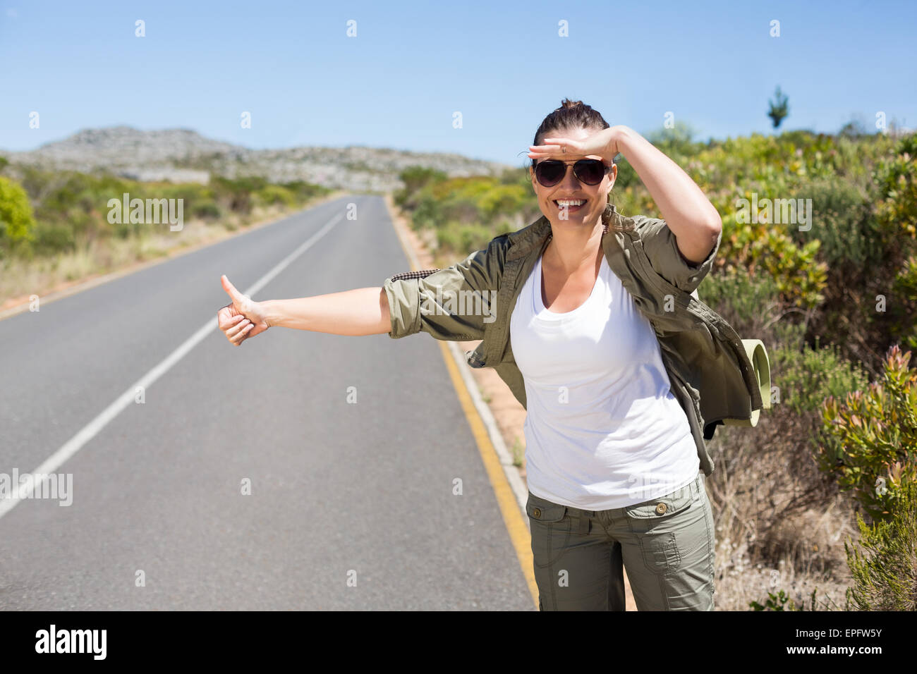 Bastante hitchhiker pulgar pegada en la carretera Fotografía de stock -  Alamy