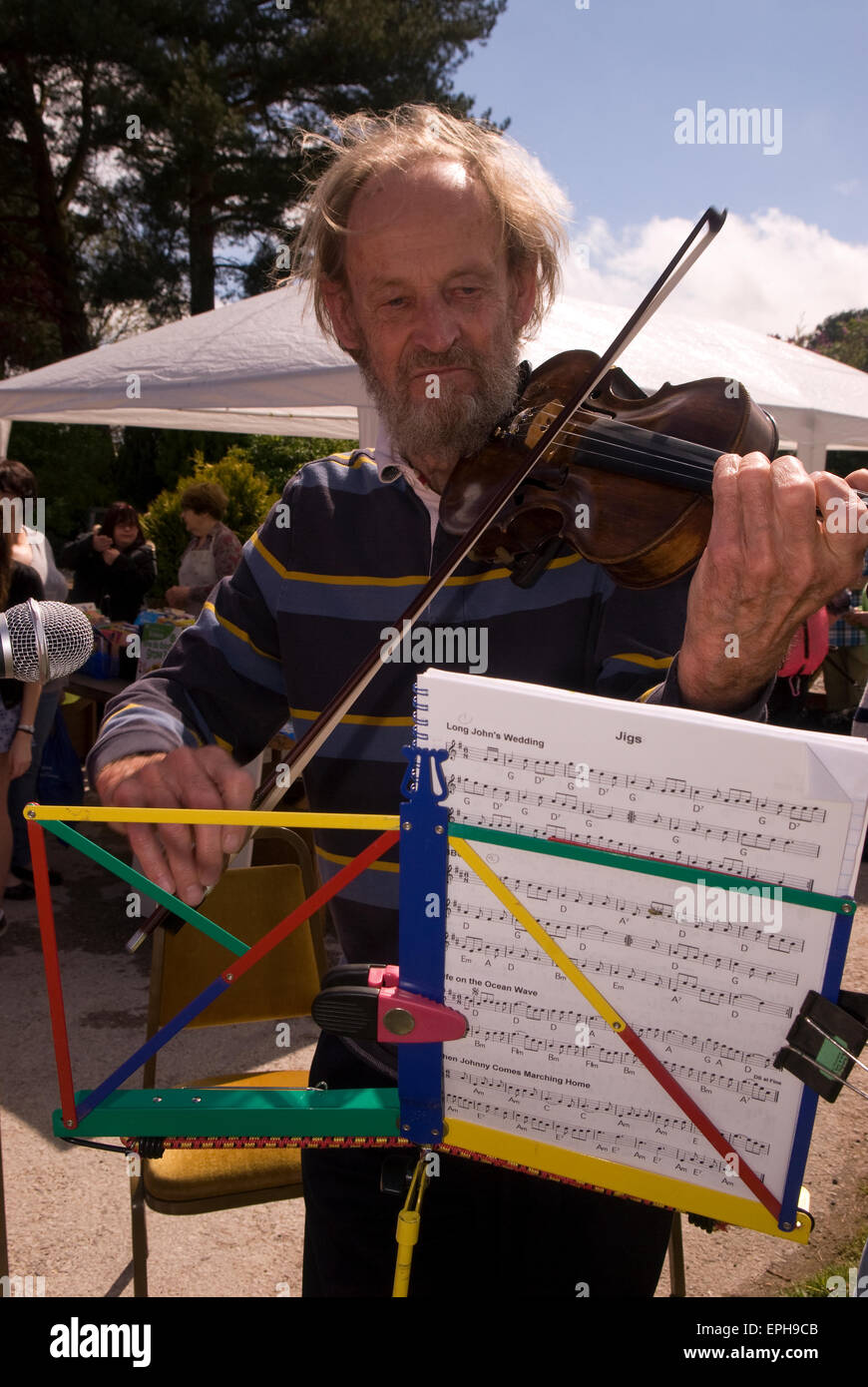 Hombre entretener a las multitudes a tocar el violín a un mayo Fayre, Oakhanger, Hampshire, Reino Unido. Foto de stock