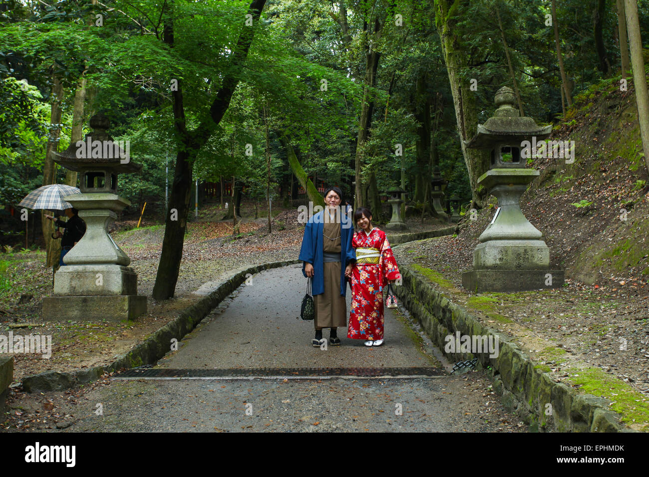 Geisha japonesa y socio en Fushimi Inari Shrine jardines en Kyoto. Foto de stock