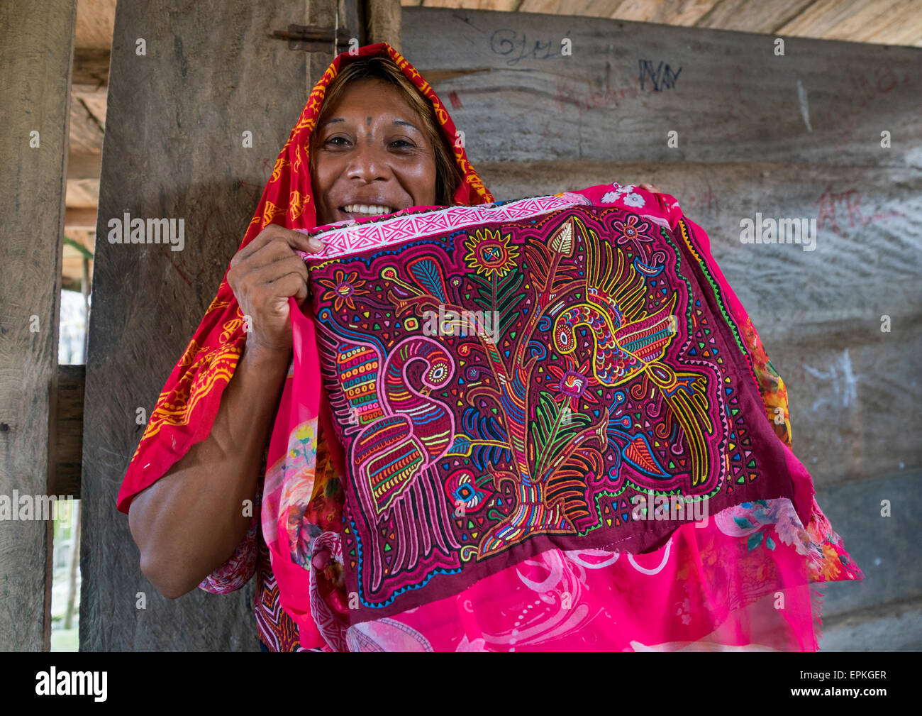 Panamá, las Islas de San Blas, Mamitupu, Gay hombre indígena Kuna vistiendo ropas tradicionales femeninos y mostrando una mola Foto de stock