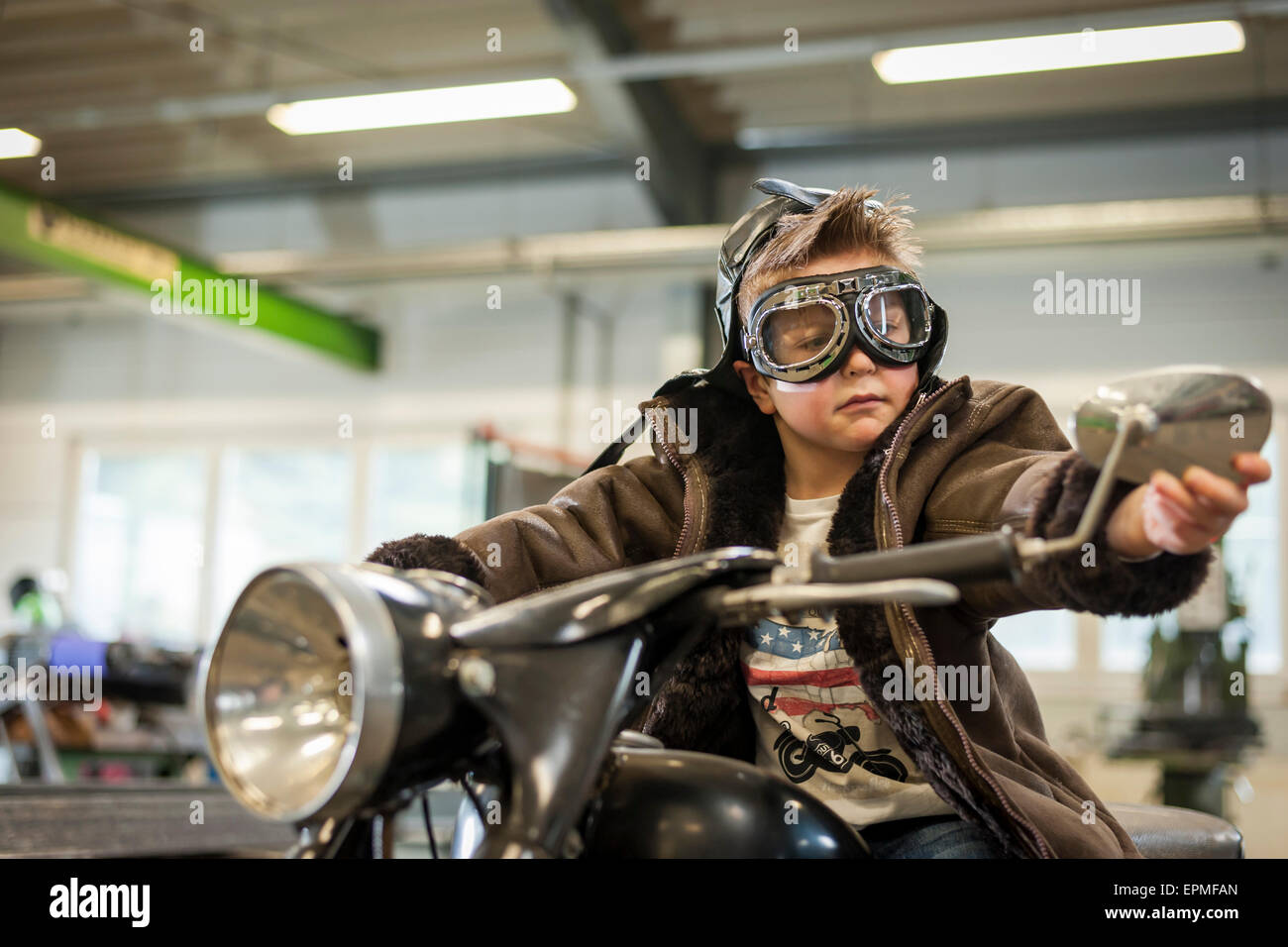 Muchacho pretendiendo conducir ciclomotor vintage Foto de stock