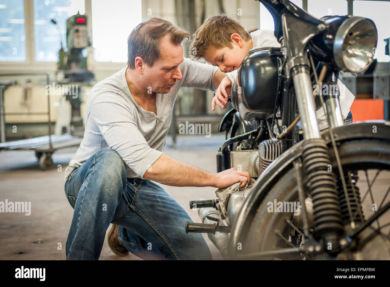 Padre e hijo mantener vintage ciclomotor Foto de stock