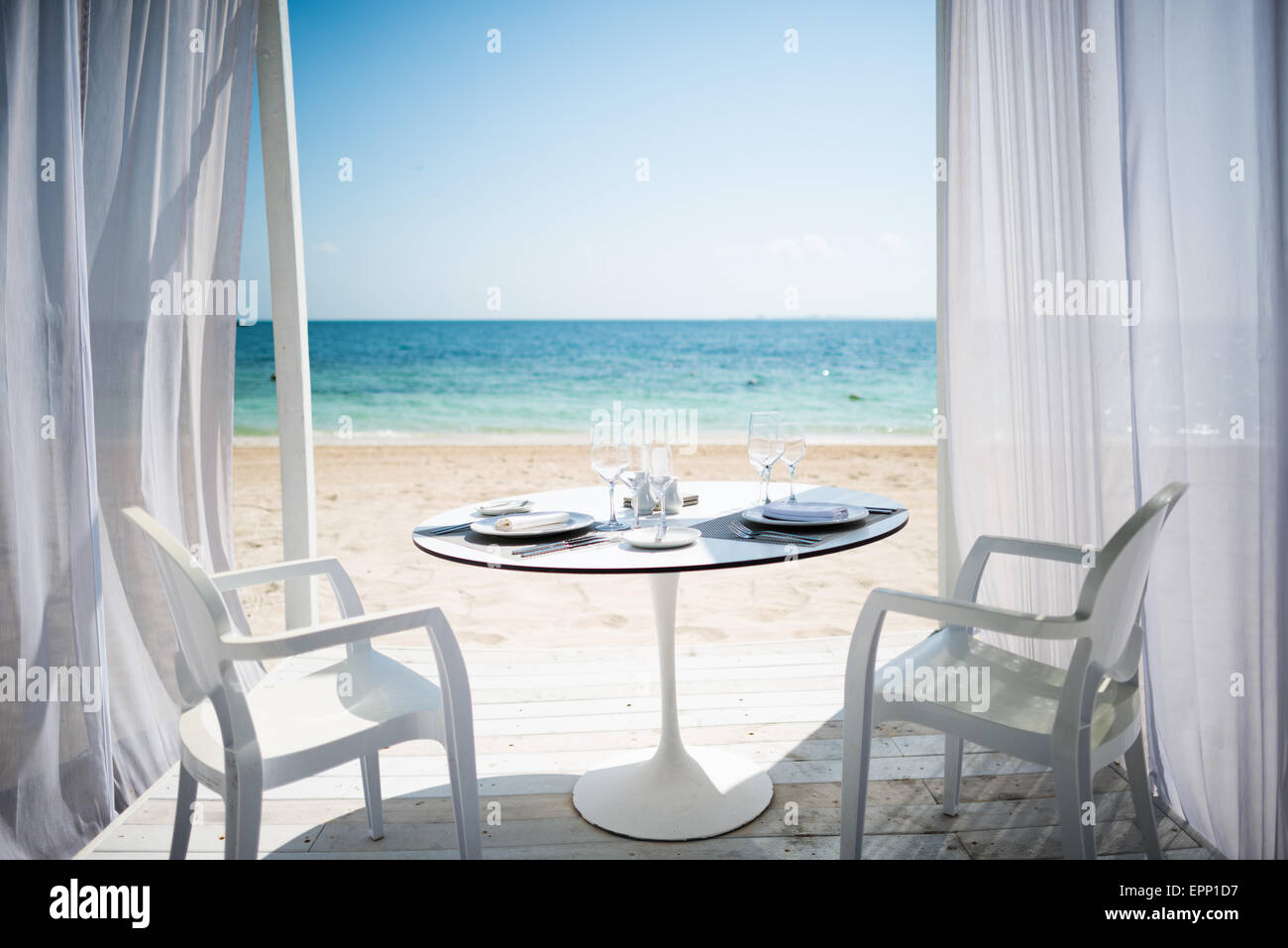 Una tabla está configurado para una cena romántica en la playa en Playa Mujeres en la costa del Caribe de México. Foto de stock