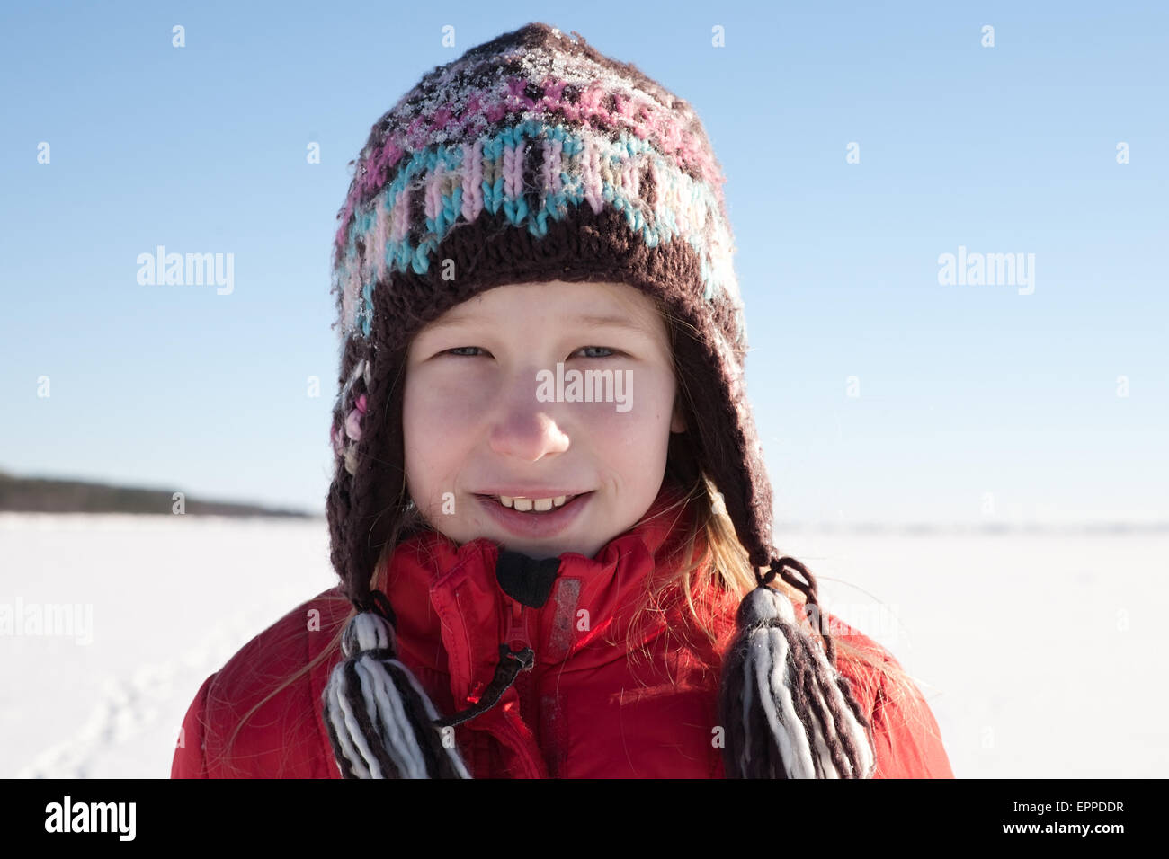 Muchacha con tapa en tejidos blancos como la nieve, y el cielo azul de fondo de campo Foto de stock
