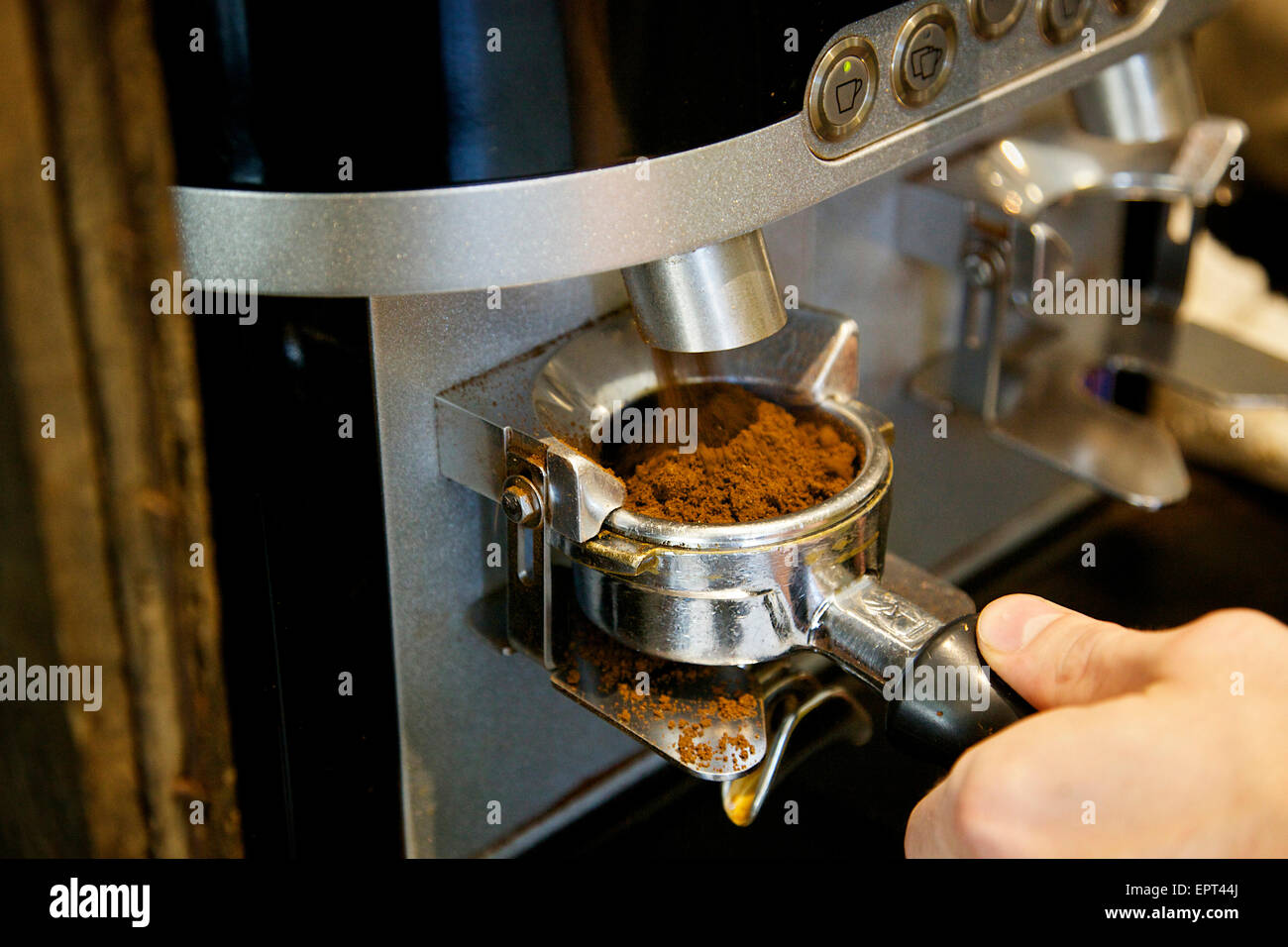 Molinillo de café automática Cesta Portafilter llenado en la cafetería. Foto de stock