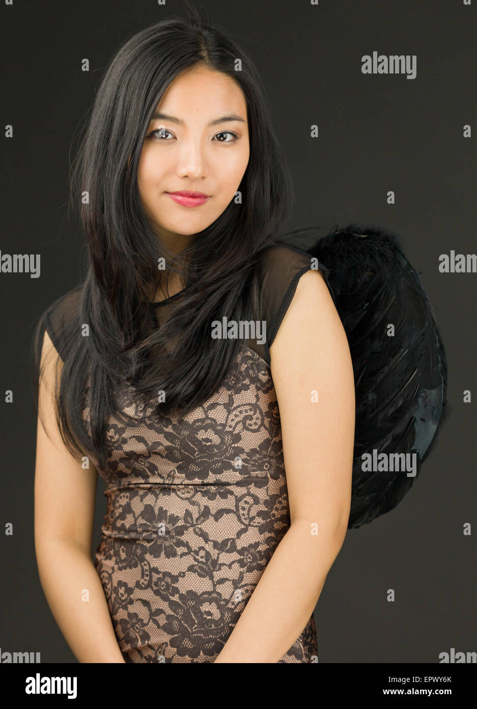 Atractiva mujer adulta joven asiática en los ángeles y demonios Foto de stock