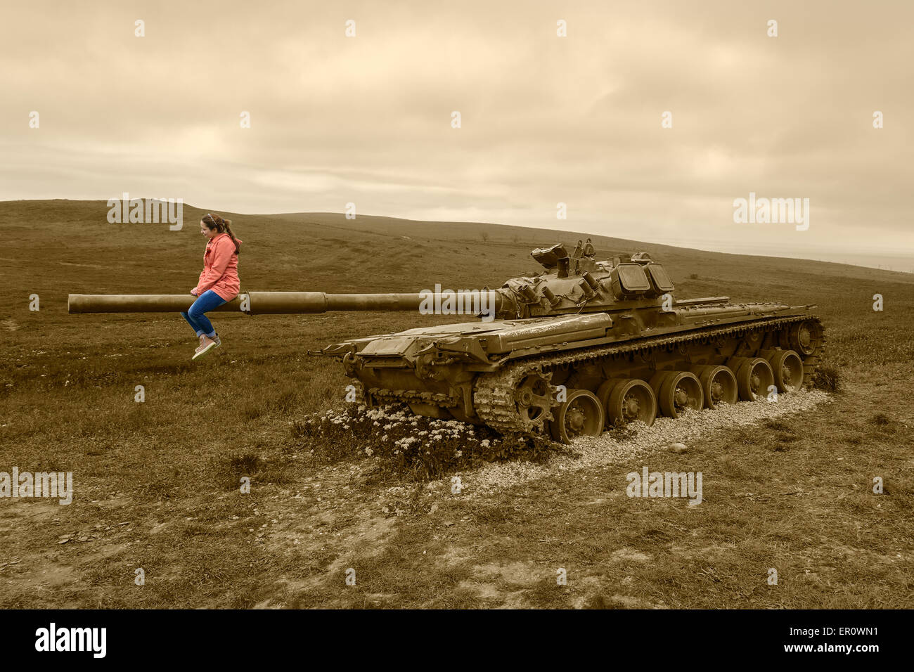 Chica sentada sobre un tanque gun . Foto de stock