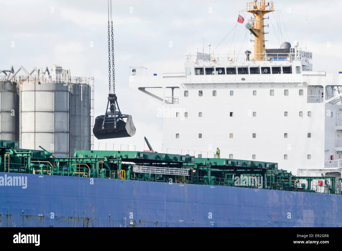 Una grúa descarga la carga de grano desde un barco. Foto de stock