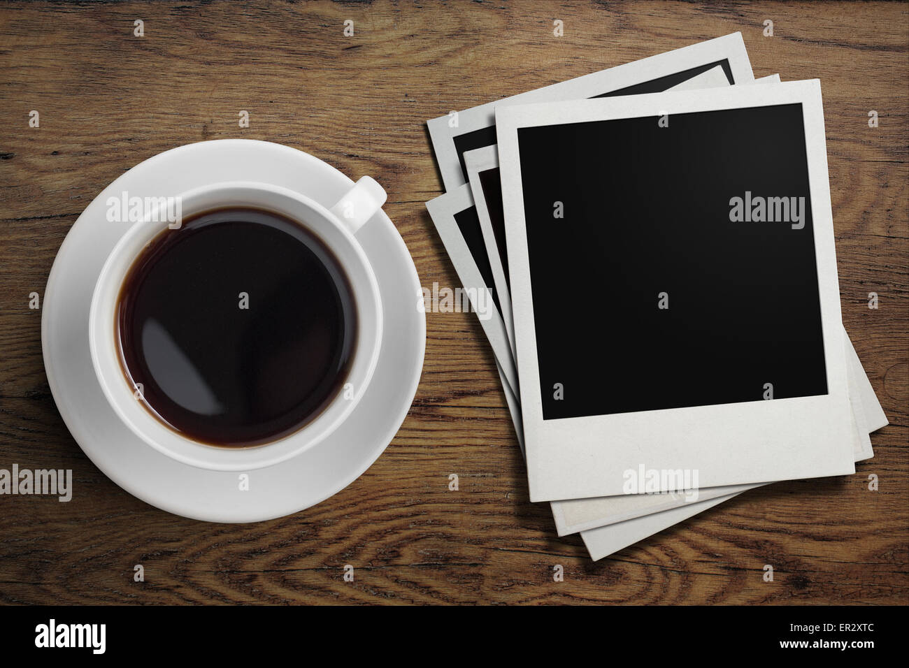 Taza de café y marcos de fotos polaroid en mesa Foto de stock