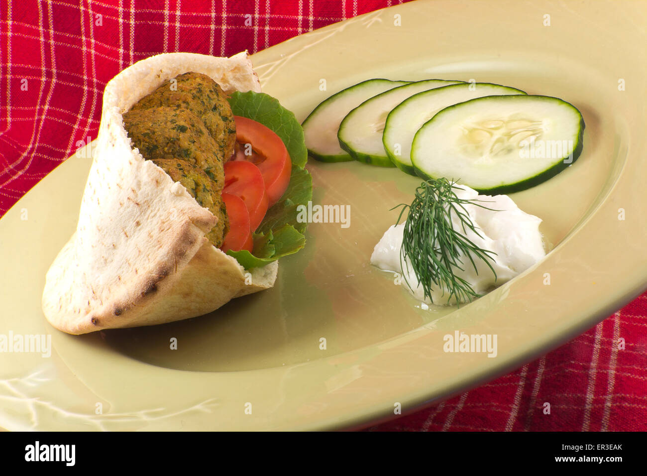 Falafel con frescos y saludables, tzatziki, pepino, tomate y lechuga romana del bebé en una pita Foto de stock