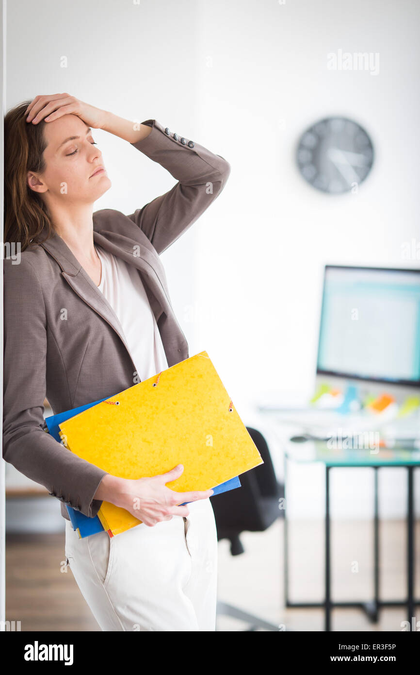 La mujer en el trabajo, sufren de dolor de cabeza. Foto de stock