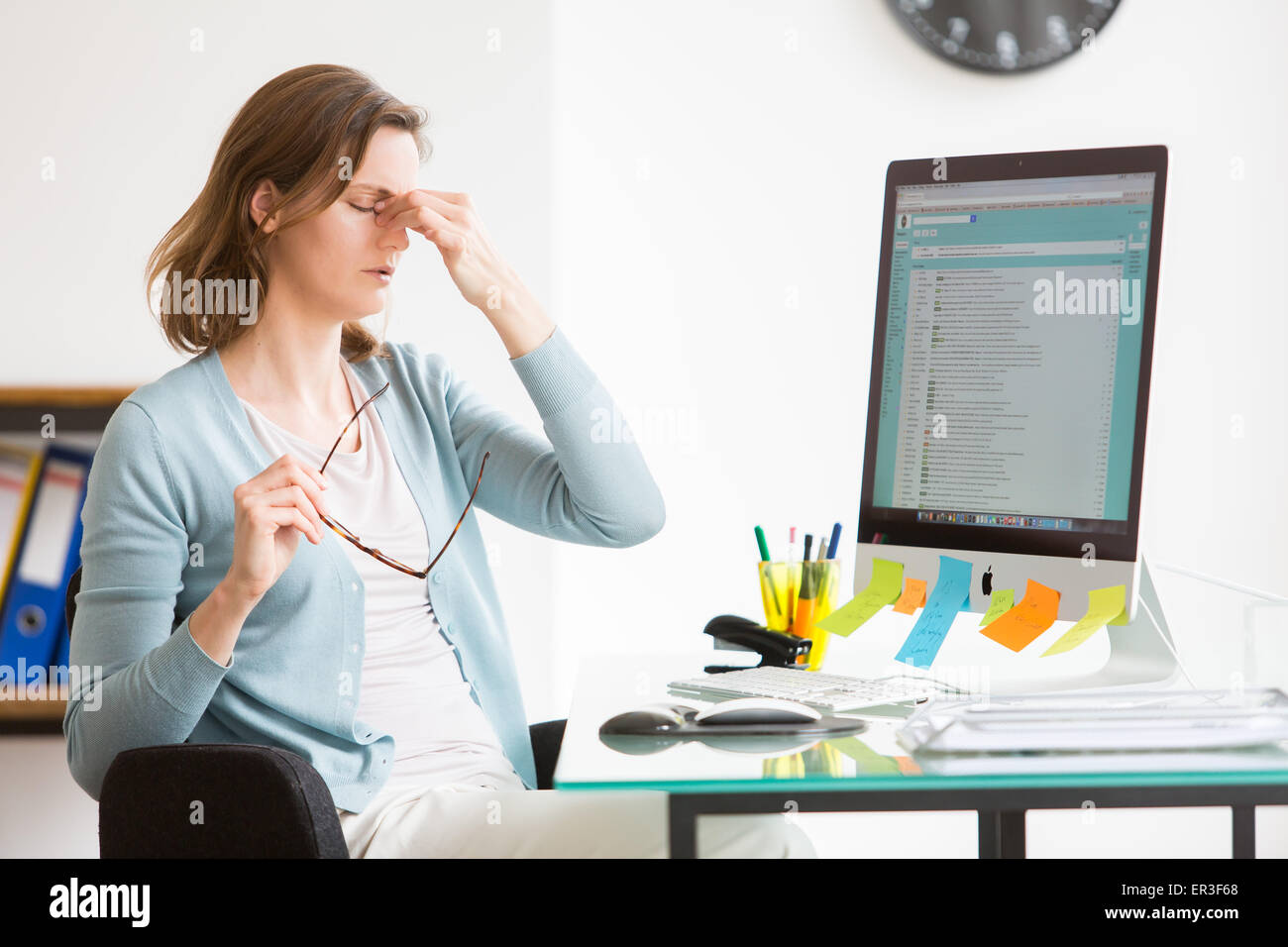 La mujer en el trabajo, sufren de dolor de cabeza. Foto de stock