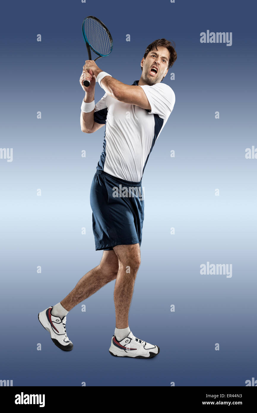 Jugador de tenis jugando sobre fondo azul. Foto de stock
