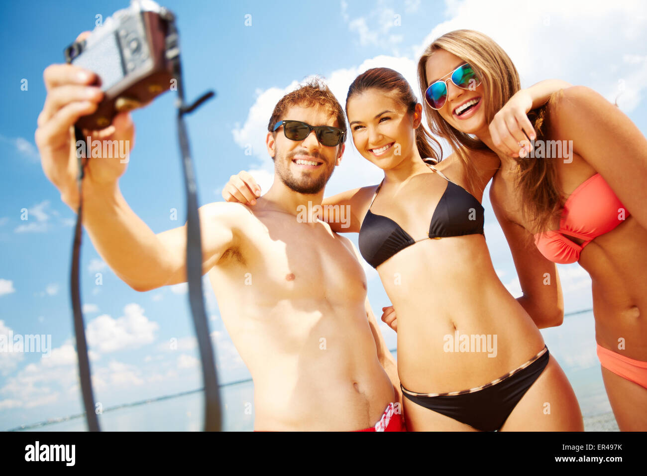 Feliz amigos tomando fotos en la playa Foto de stock
