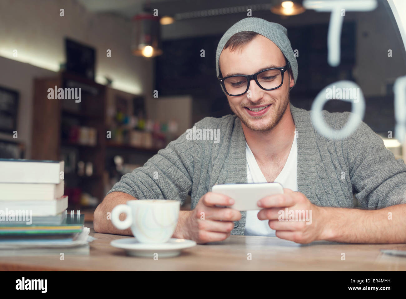 Hipster Hombre con teléfono móvil en el cafe. Cracovia, Polonia Foto de stock