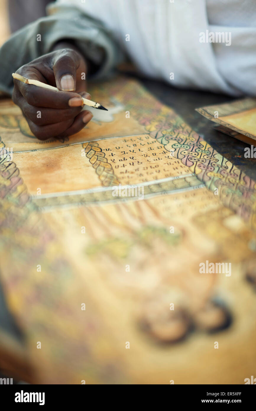 Sacerdote pintando y escribiendo escenas bíblicas en el Geez goatskin, Bet Giyorgis, Iglesia de San Jorge, Lalibela, la región de Amhara, Et Foto de stock