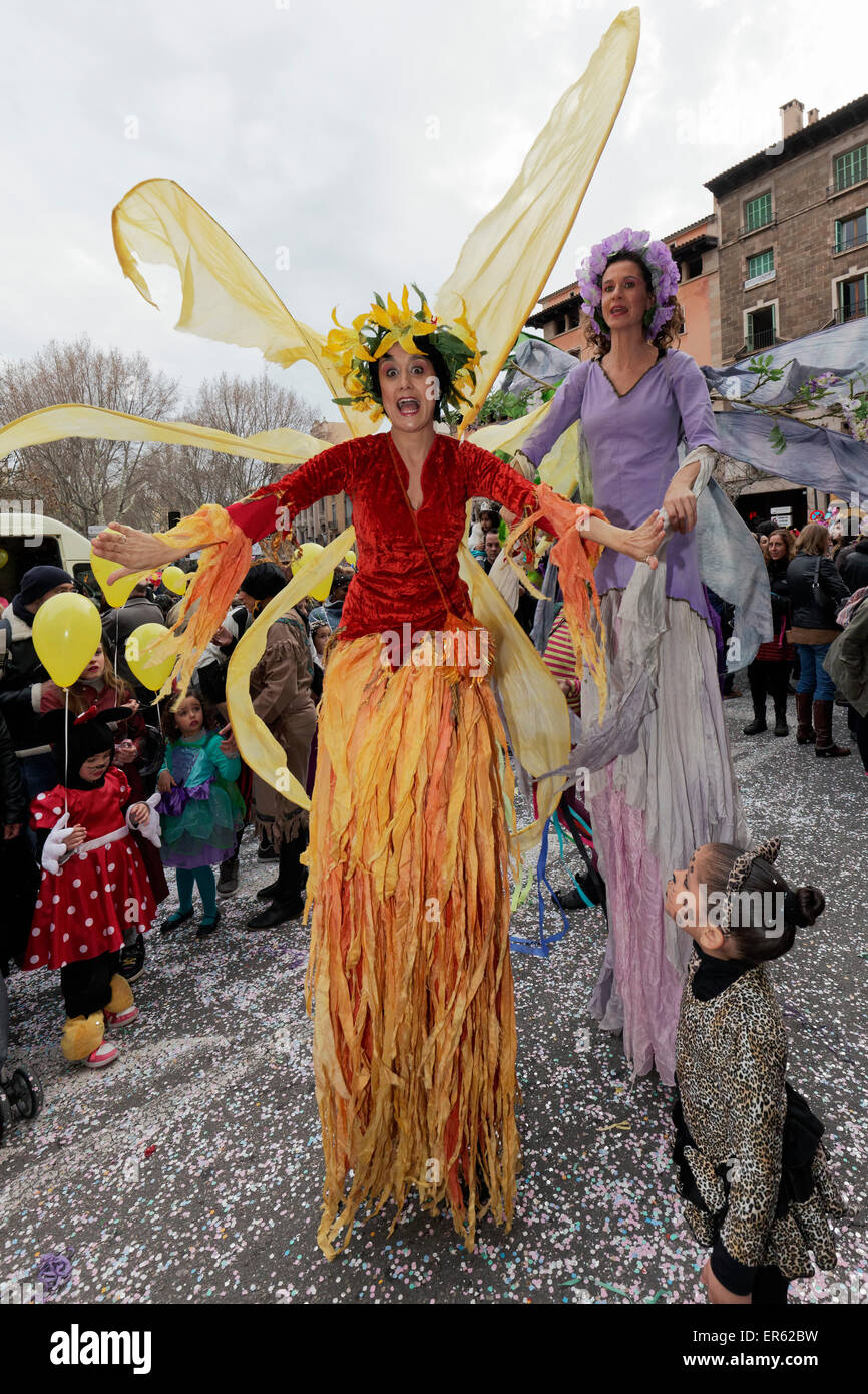 Acróbatas sobre zancos, vestida como coloridas mariposas carnaval callejero, Palma de Mallorca, Islas Baleares, España Foto de stock