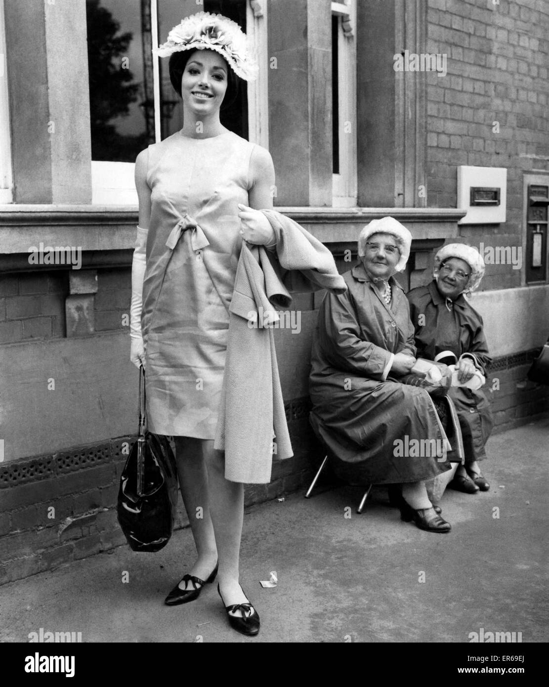 Ropa de moda : Sombreros de Ascot. Miss Carol Jeffery (20) vestidos de con rosas de encaje tieso hat vigilado por dos ancianas. Junio de 1965 P002856 de stock - Alamy