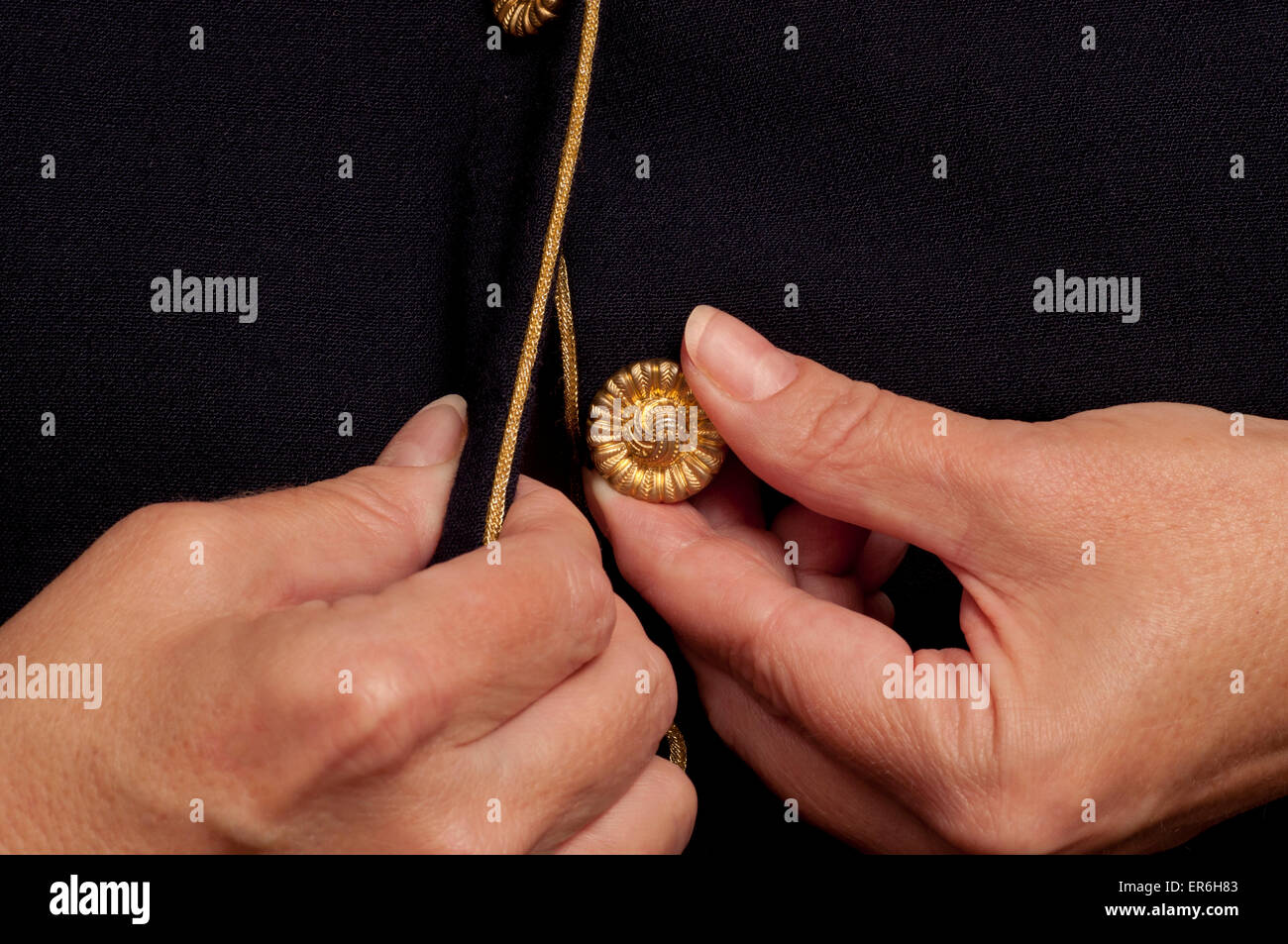 Mujer con artritis tratando de botón a botón con dolorosas manos. Foto de stock