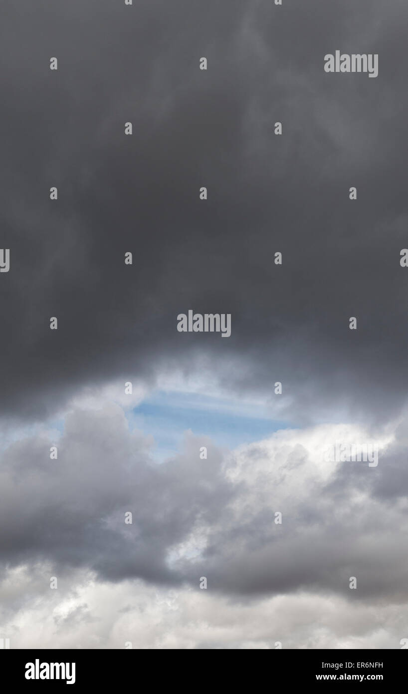 Agujero en las nubes de lluvia que muestra un cielo azul. Escocia Foto de stock