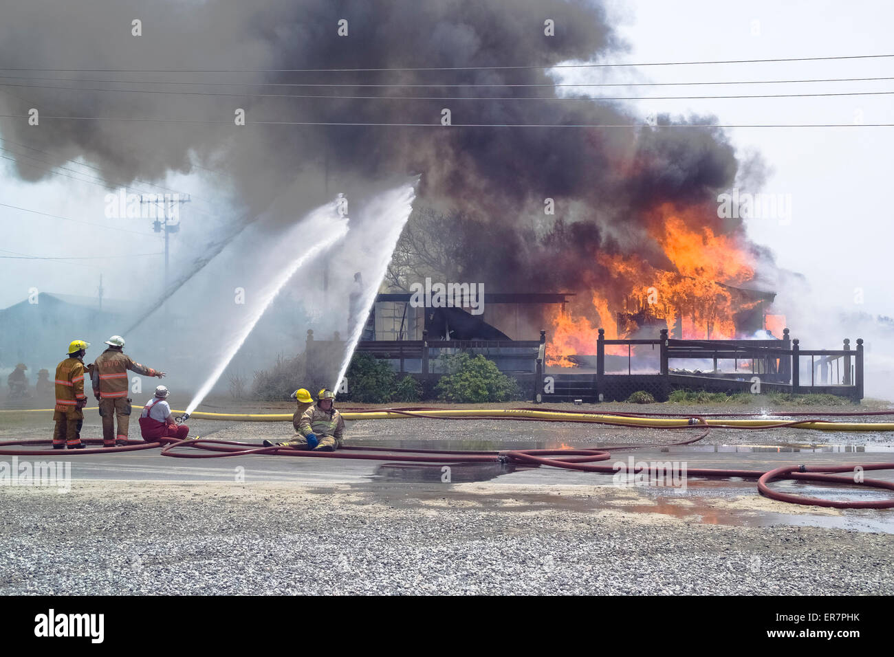 Bomberos pulverizar agua en un edificio abandonado que se ha incendiado el bombero para fines de entrenamiento en Cabo Hatteras, en Carolina del Norte, EE.UU. Foto de stock