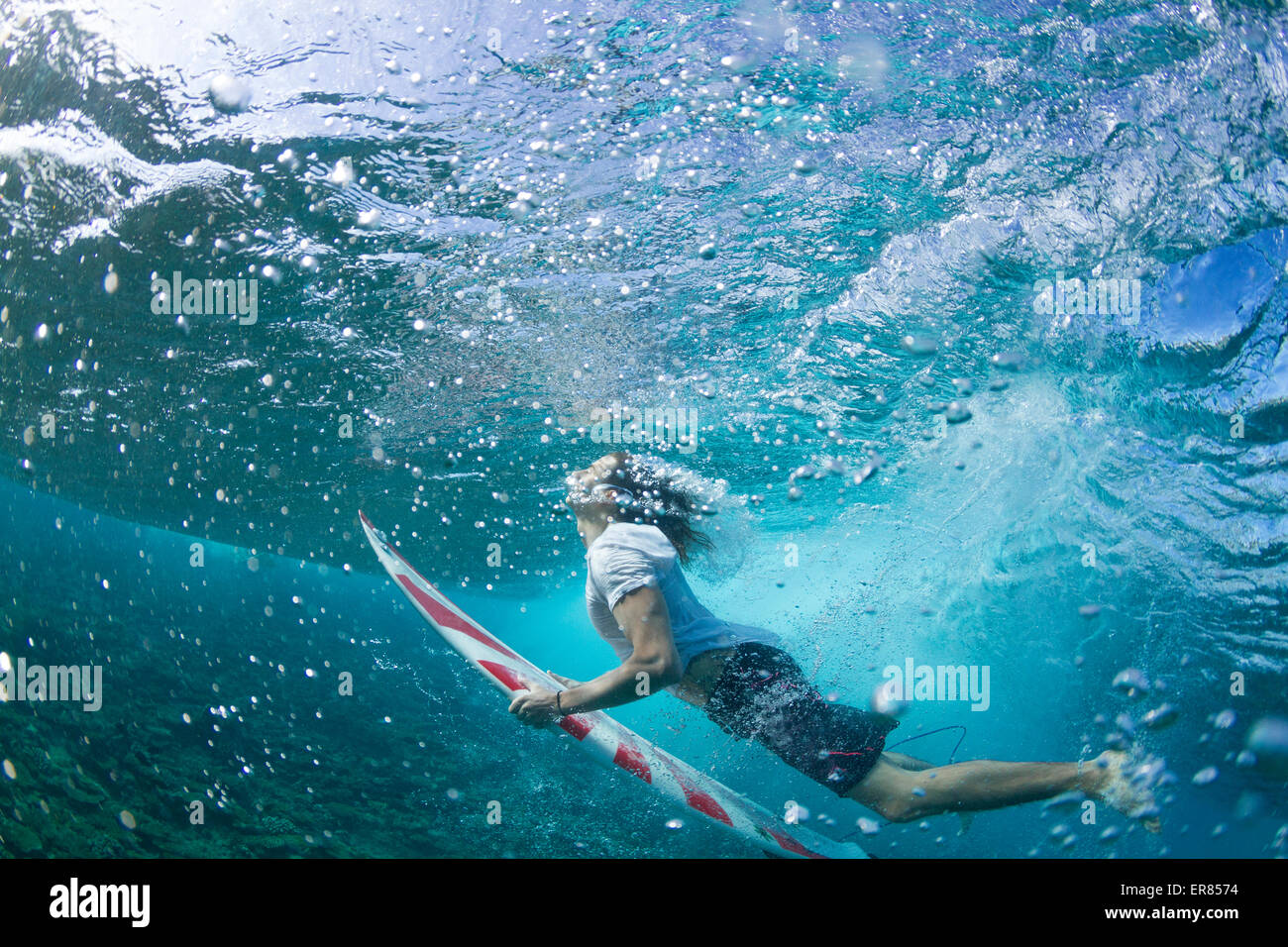 Vista submarina de un surfista pato de buceo bajo una ola Foto de stock