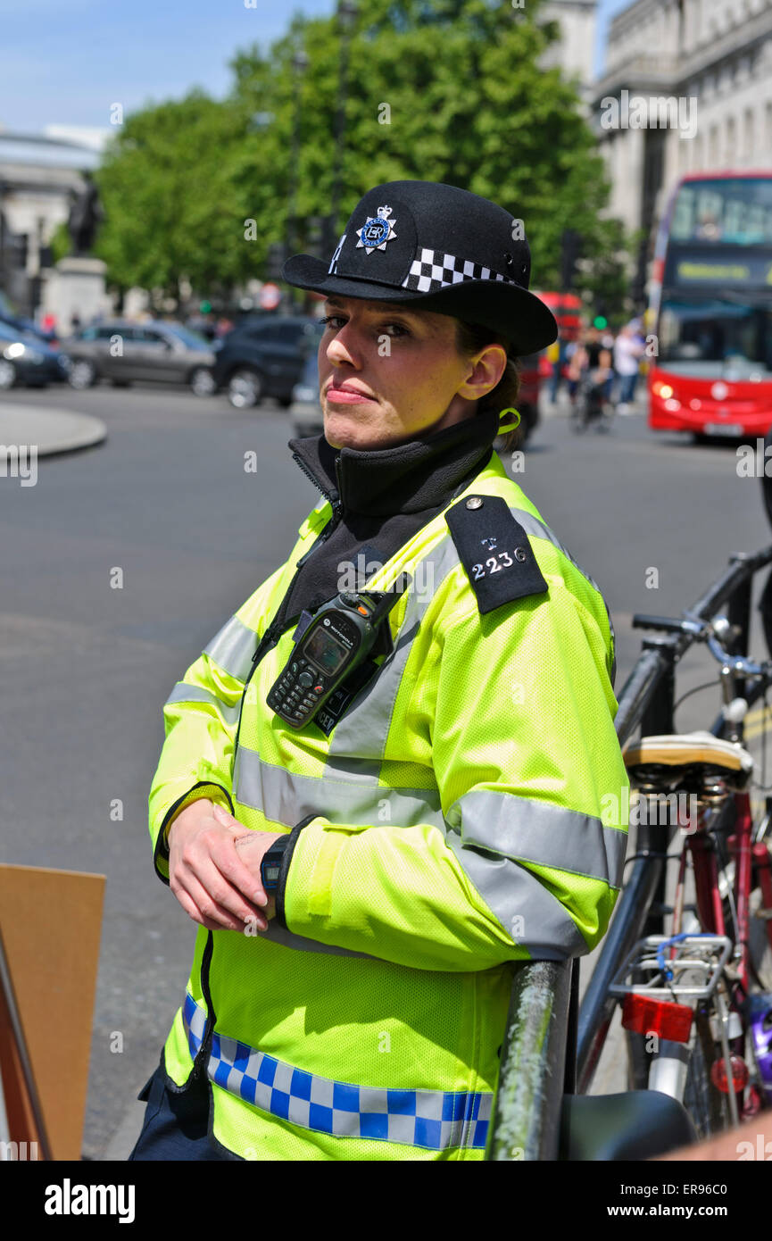 Una funcionaria de la policía metropolitana en amarillo brillante chaqueta en lugares en Londres, Inglaterra. Foto de stock
