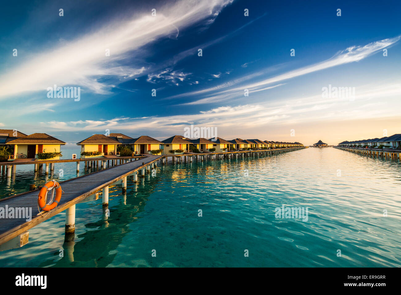 Tiempo Sunset en la isla de Maldivas en el puente que une bungallows sobre el agua Foto de stock