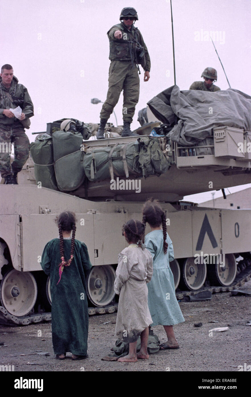 23 de marzo de 1991 niños chiítas iraquíes se encuentran junto a un tanque de Abrams del Ejército de los Estados Unidos en un campamento cerca de Safwan, en el sur de Irak, cerca de la frontera con Kuwait. Foto de stock