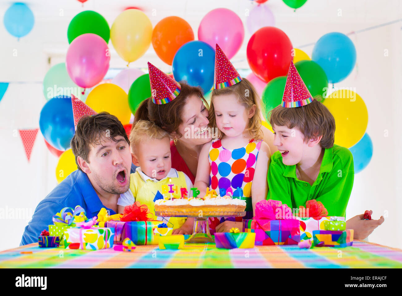 Familia feliz celebración de cumpleaños para niños. Los padres y tres hijos  celebrar juntos. Fiesta infantil con decoración con globos Fotografía de  stock - Alamy