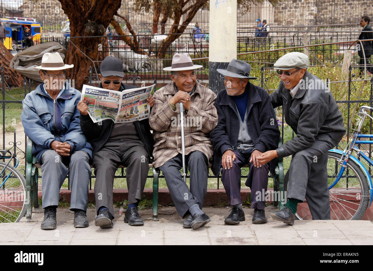 Los hombres socializar en un banco del parque en el municipio Plaza, Lampa, Perú Foto de stock