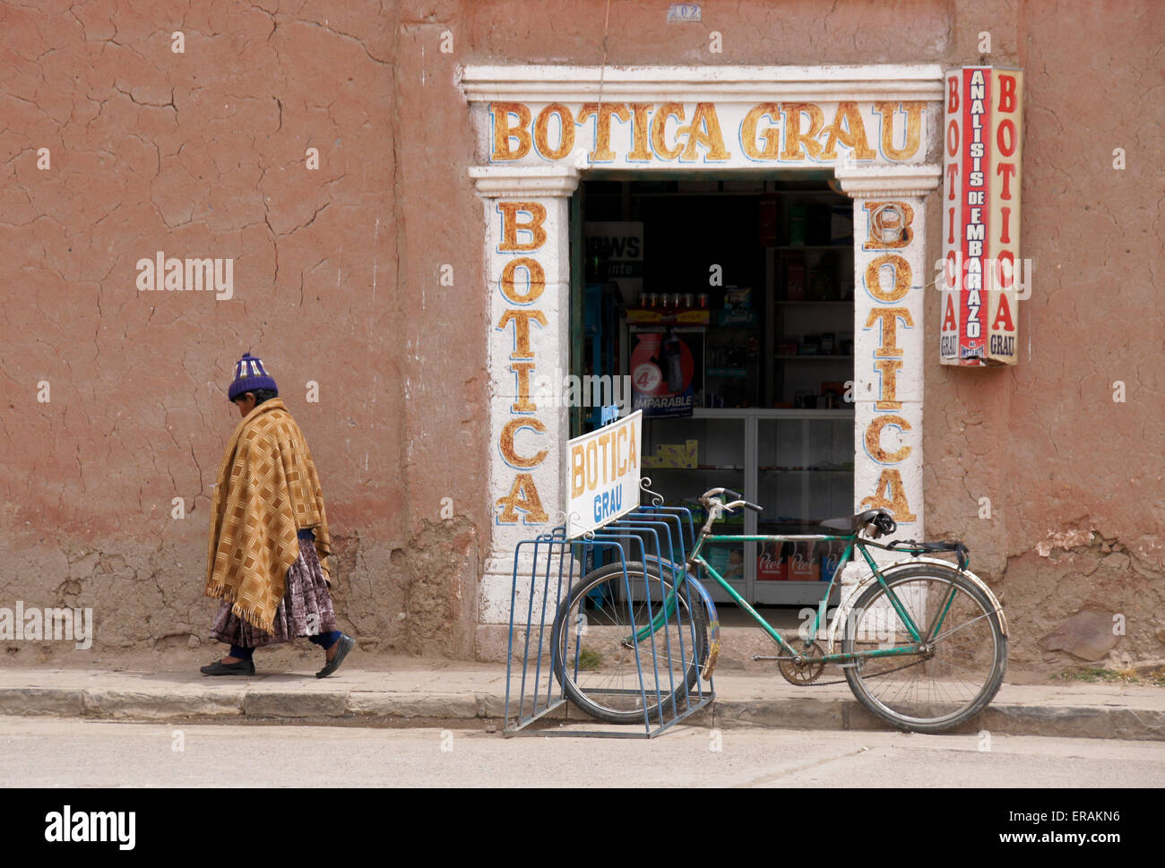 Mujer caminando por la farmacia, Lampa, Perú Foto de stock