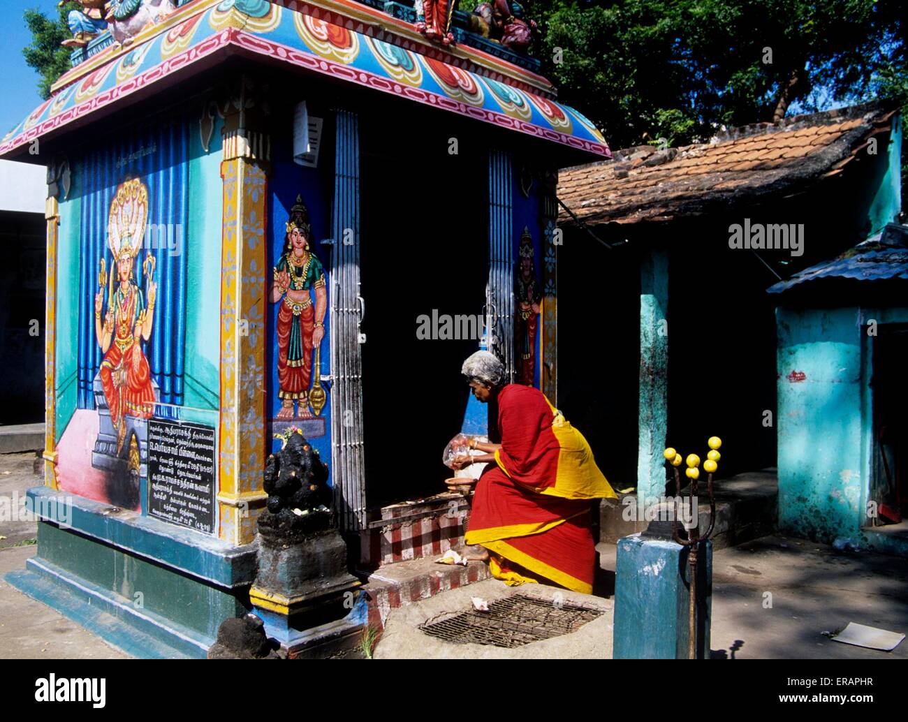 Mujer ofreciendo puja en un templo de aldea en Tamil Nadu Foto de stock