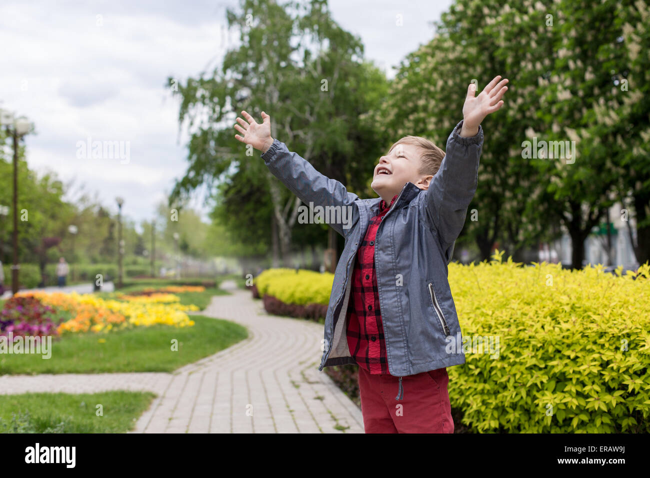 Niño feliz con camiseta roja en el jardín
