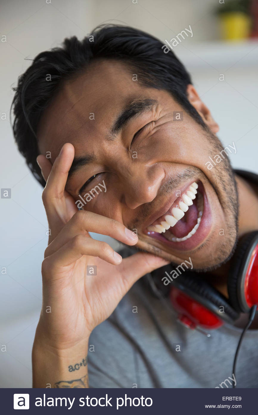 Retrato hombre entusiasmado con auriculares riendo Foto de stock