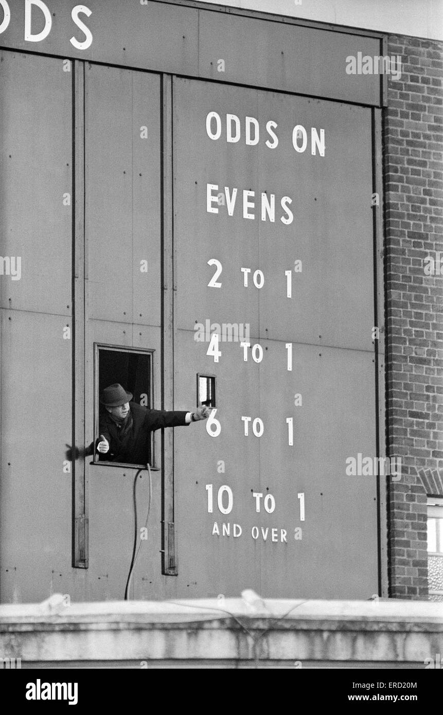 Detrás de las escenas en Sandown Park antes de una reunión de dos días. La enorme tote junta que registra las probabilidades con el hombre de mantenimiento dando los pulgares hacia arriba para salir de la ventana. El 28 de diciembre de 1967. Foto de stock