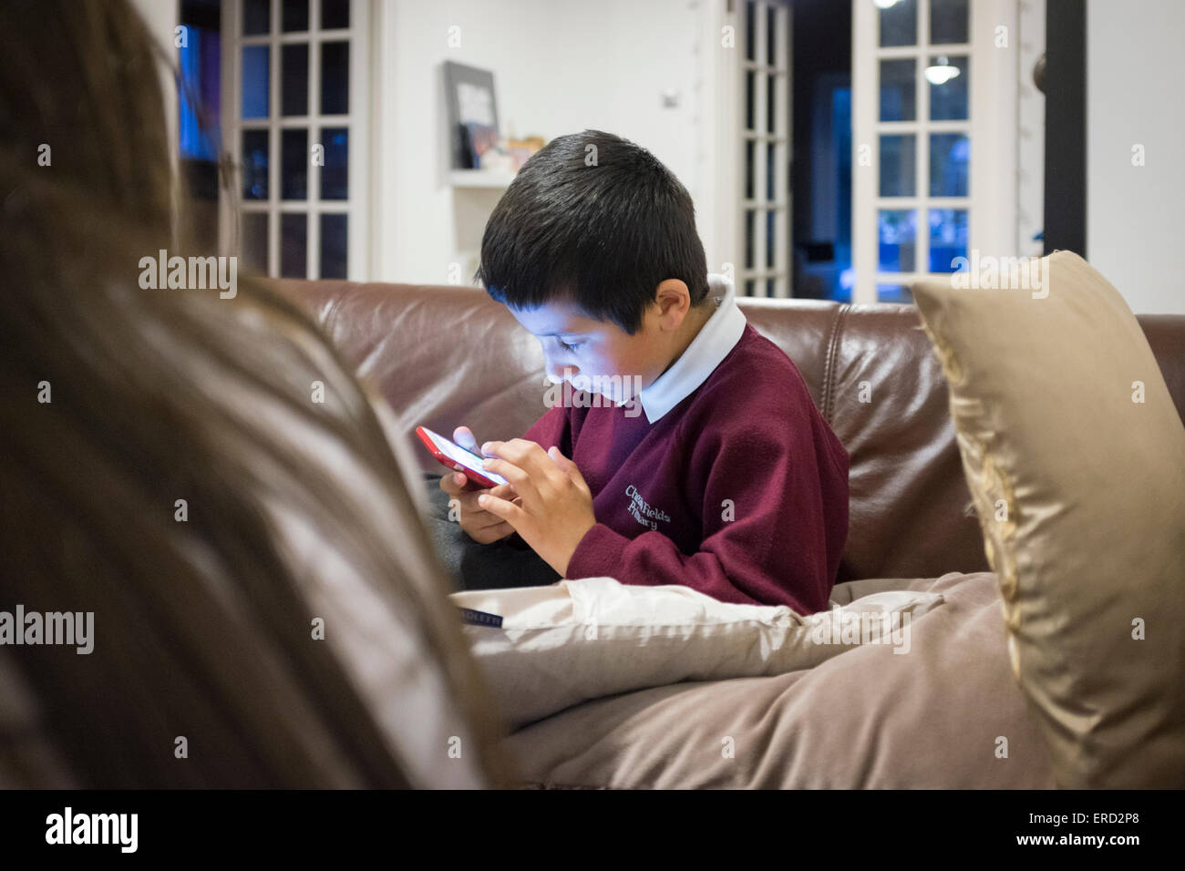 El colegial,7,jugar en teléfonos inteligentes. Foto de stock