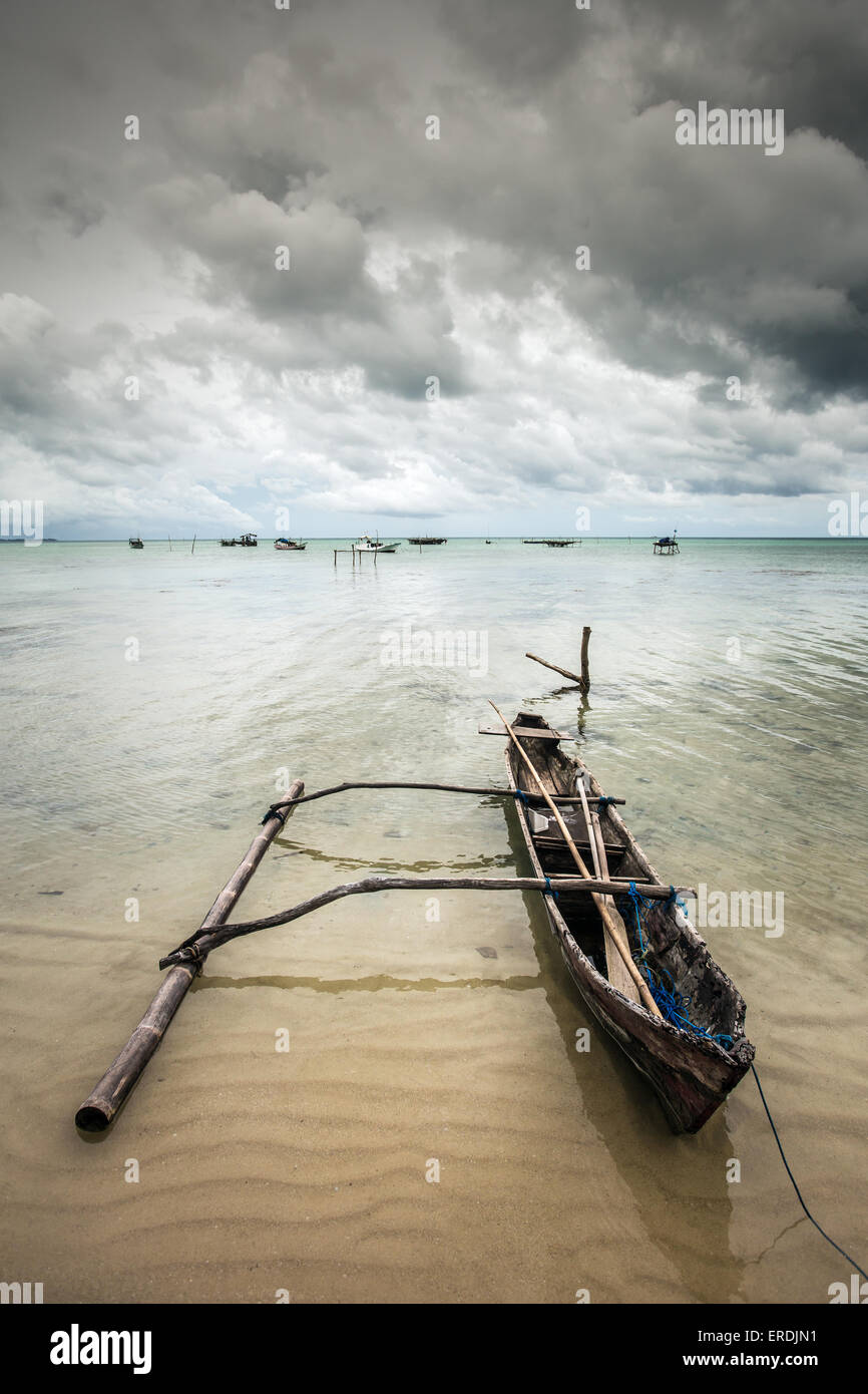 Barco de pescadores en la orilla del mar en un día nublado Foto de stock