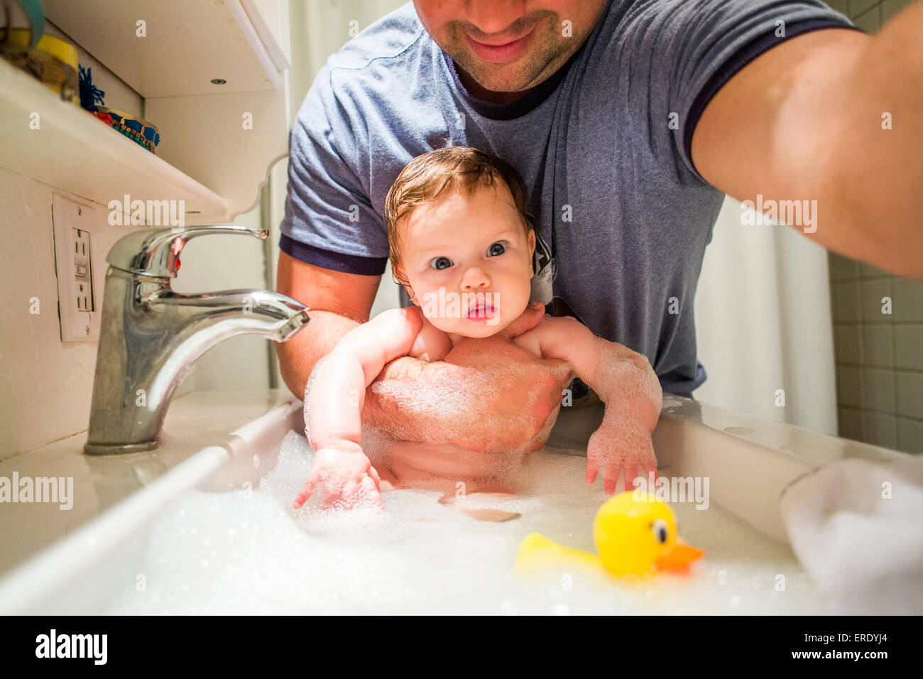 Cerca de caucásico padre niña bañarse en el fregadero Foto de stock