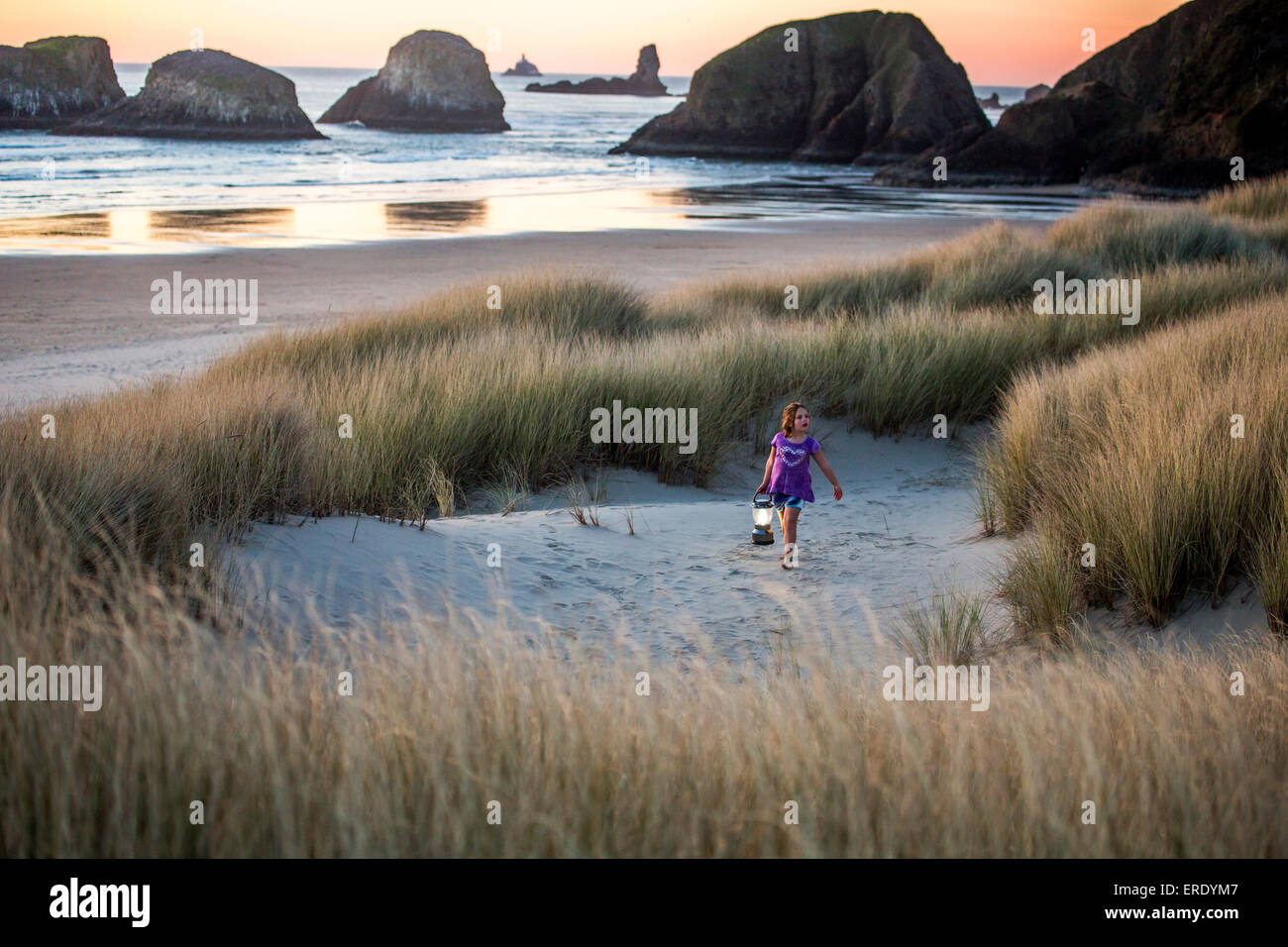 Chica caucásica llevar linterna en la playa Foto de stock