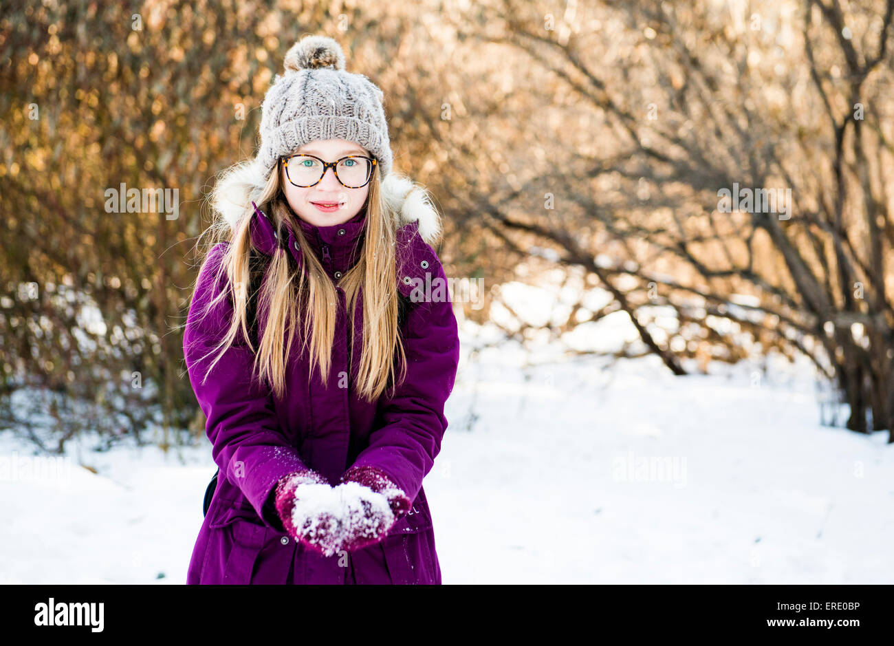 Caucasian Chica sujetando la nieve en el campo Foto de stock