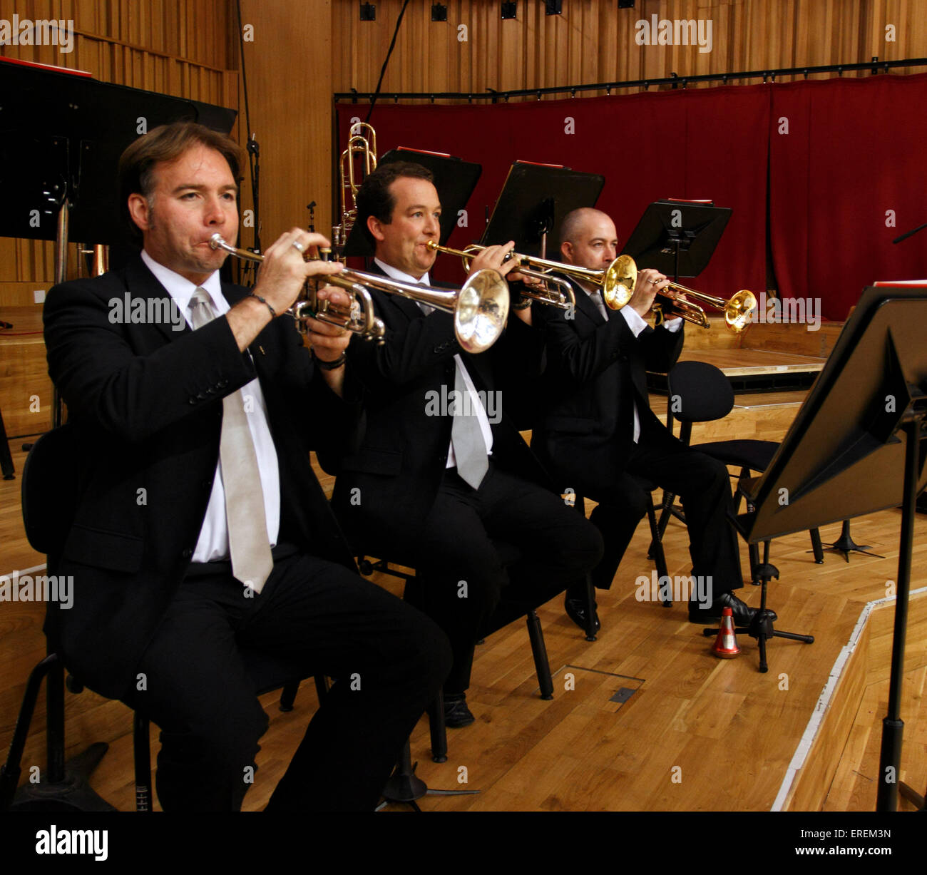 Sección de trompeta orquestal, tres jugadores celebrando sus trompetas. Foto de stock