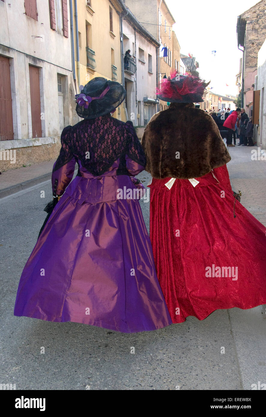 Dos señoras en trajes de estilo victoriano (vista posterior) tomar parte en un desfile del Día de San Valentín en la aldea de Roquemaure, Sur Foto de stock