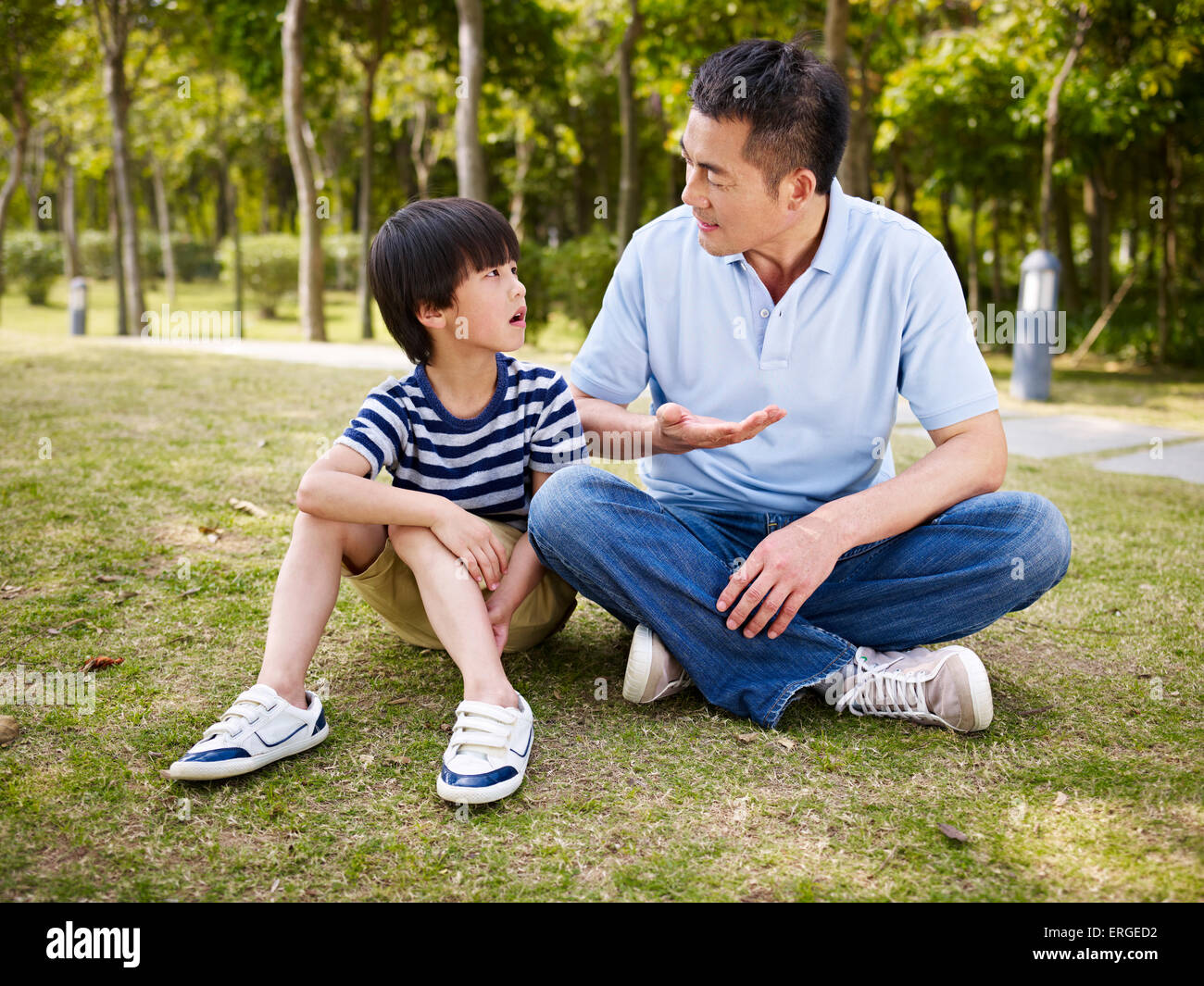 Padre e hijo asiáticos hablando al aire libre Foto de stock