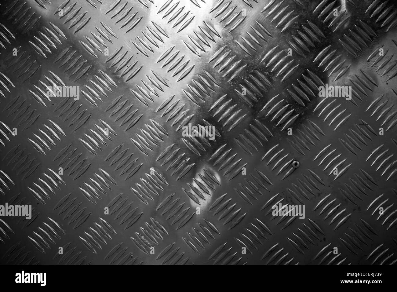 Oscuro brillante superficie metálica con placa de diamante industrial patrón de descarga Foto de stock