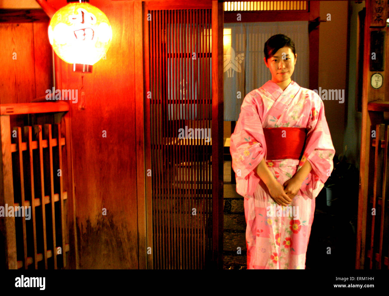 Un joven Geiko se sitúa delante de la Okiya, (Geisha House), Kyoto, Japón. Foto de stock